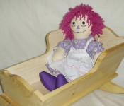 raggedy ann doll and wooden cradle