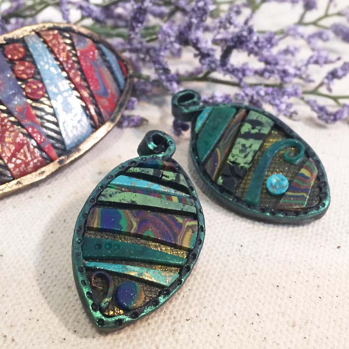 polymer clay pendant with layers of textures and veneer sheets in green shades