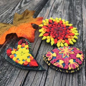 mandala designs in yellow, red and orange colors made with polymer clay