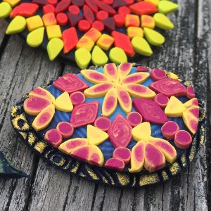 mandala designs in yellow, red and orange colors made with polymer clay